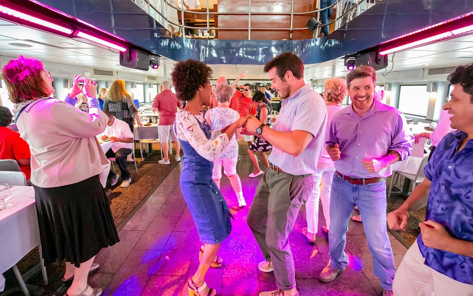 People enjoying a sunset party cruise on a boat in New York City.