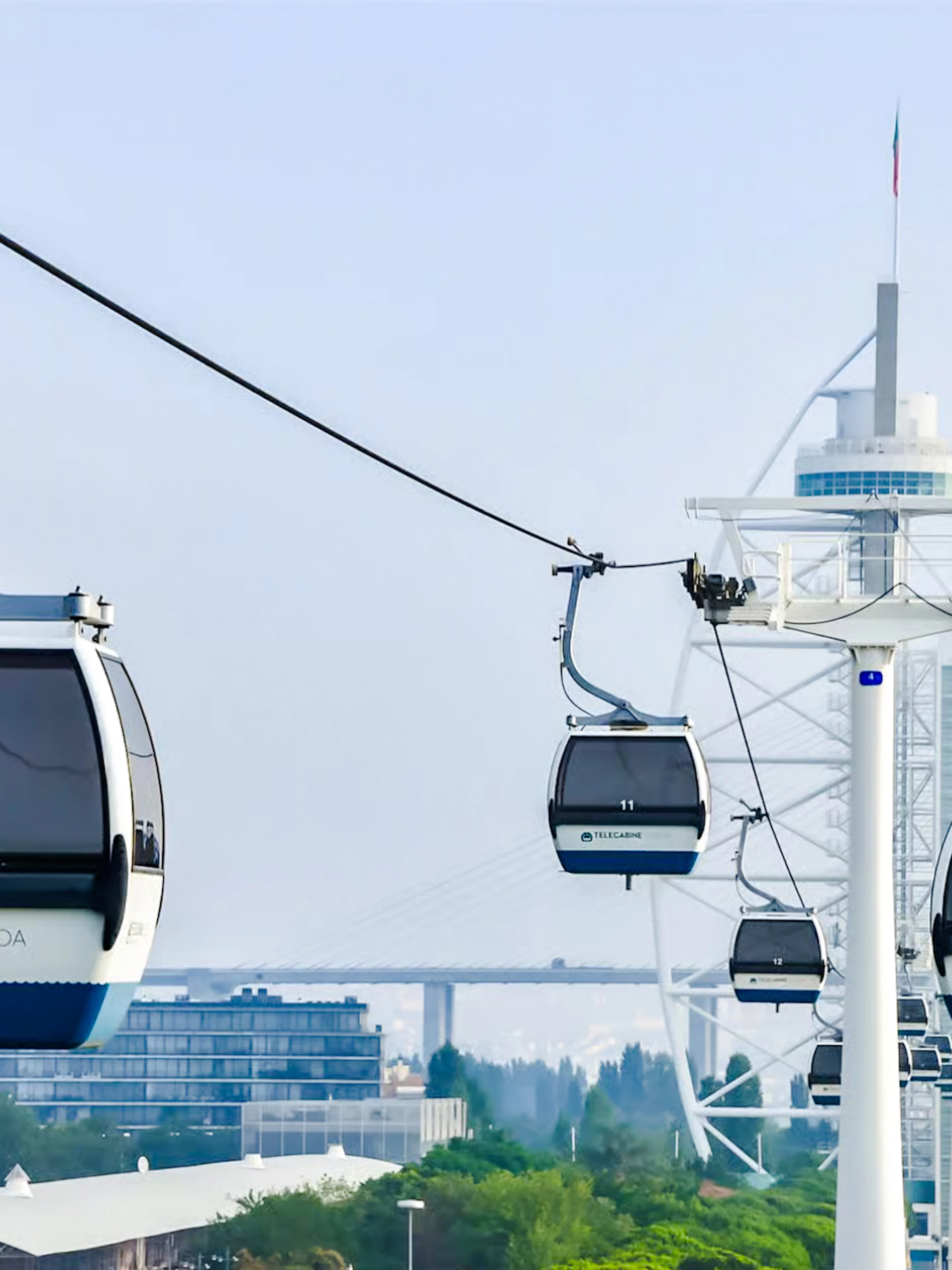 Lisbon cable cars over the cityscape with modern buildings in the background.