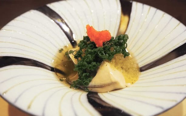 Sushi dish with garnish at Sushi Kurusu omakase in Tokyo.