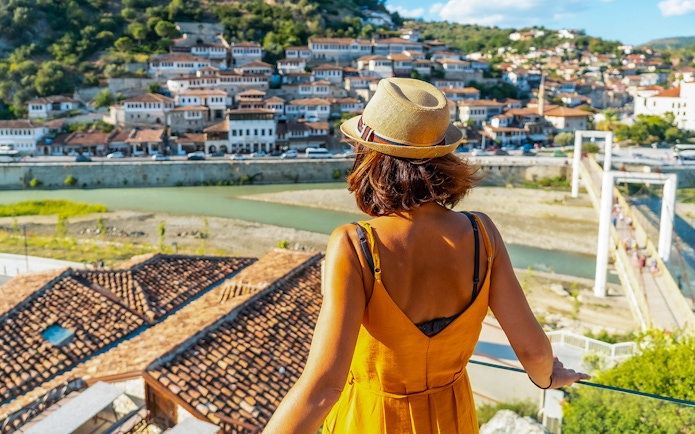 Visitor overlooking Berat's historic old town and river.