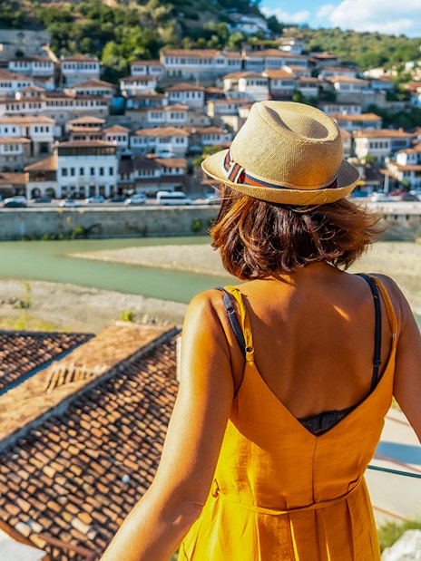 Visitor overlooking Berat's historic old town and river.