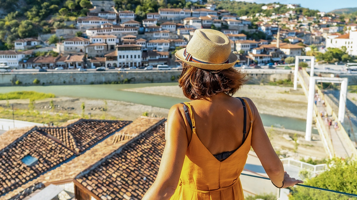 Visitor overlooking Berat's historic old town and river.