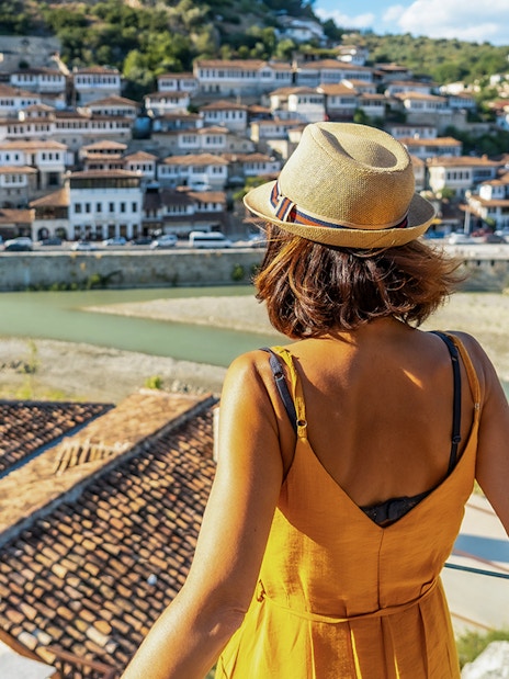 Visitor overlooking Berat's historic old town and river.