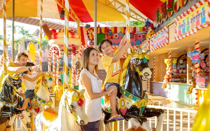 Family enjoying carousel ride at Sunway Lagoon theme park.