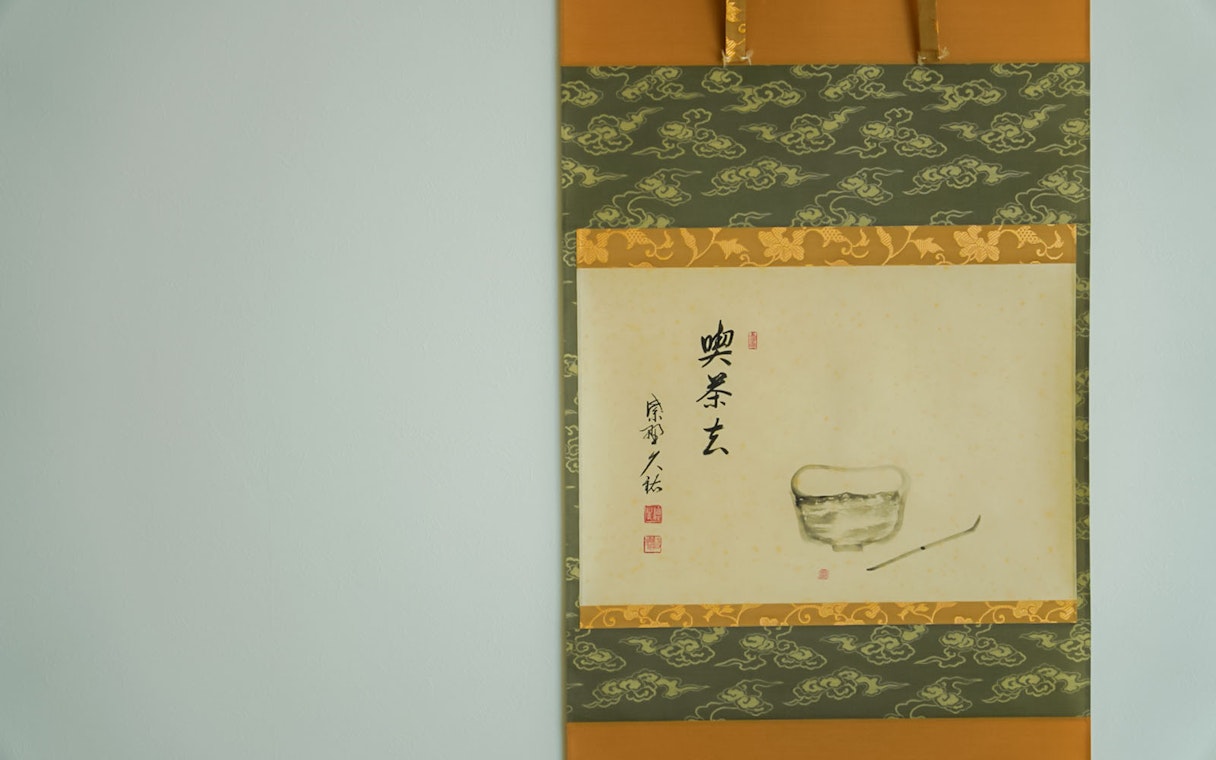 Hanging scroll with calligraphy and tea bowl illustration at Tokyo Matcha & Kimono Experience.