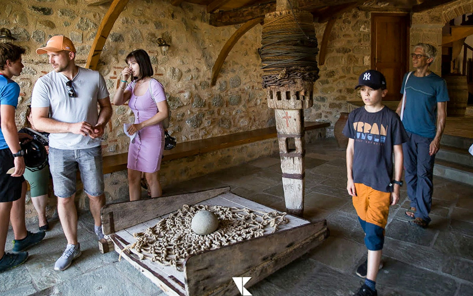 Tourists exploring inside Meteora Monastery, observing historical artifacts.
