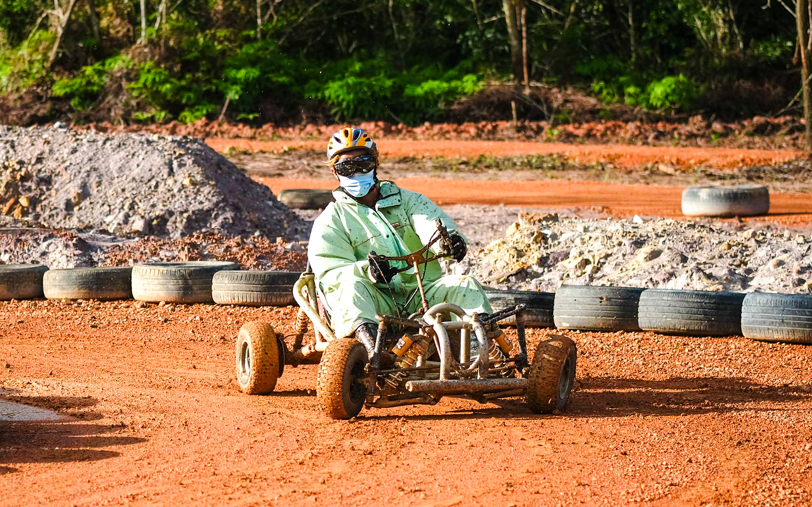 Person driving a go-kart on a dirt track at Batam Adventure Park.
