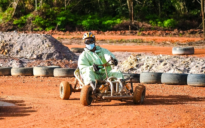 Person driving a go-kart on a dirt track at Batam Adventure Park.