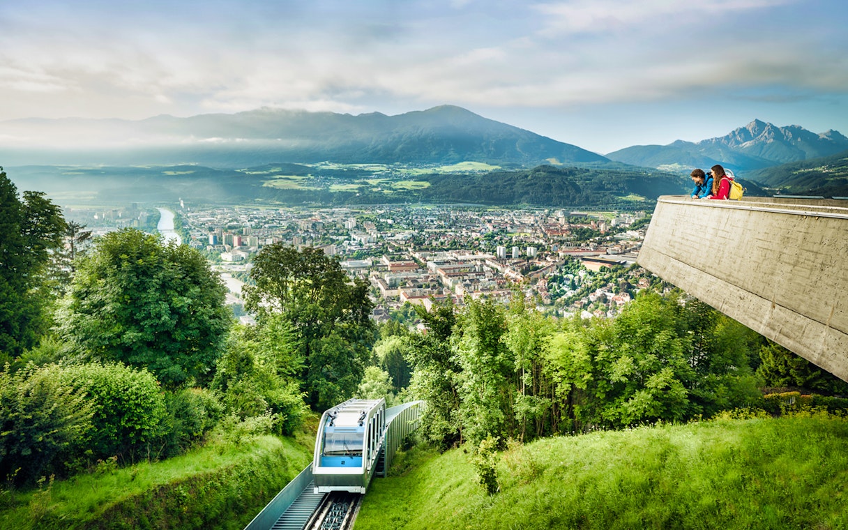 Nordkette Cable Car overlooking Innsbruck cityscape and mountains.
