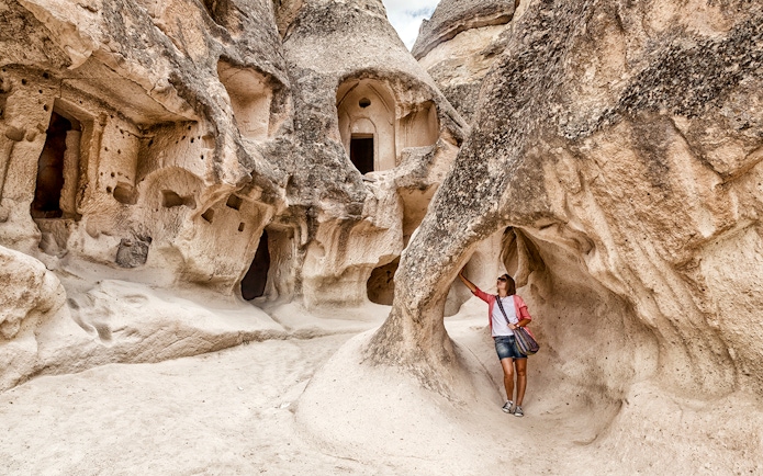 Guest exploring rock formations at Goreme Open Air Museum, Cappadocia.