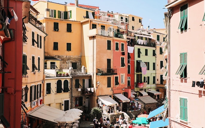 Colorful buildings in Vernazza, Cinque Terre, with tourists exploring the narrow streets.