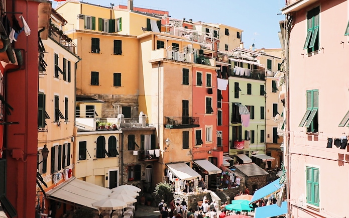Colorful buildings in Vernazza, Cinque Terre, with tourists exploring the narrow streets.