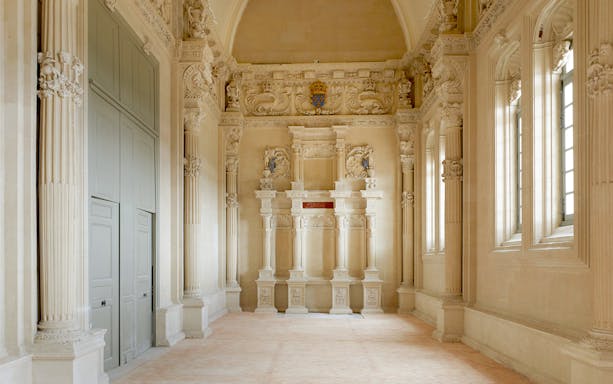 Interior of Cité internationale de la langue française with ornate columns and detailed carvings.