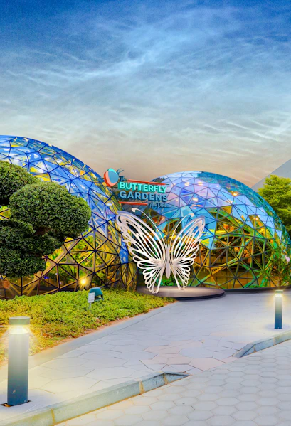 Butterfly Gardens entrance with geometric dome and illuminated butterfly sculpture.