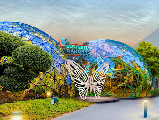 Butterfly Gardens entrance with geometric dome and illuminated butterfly sculpture.