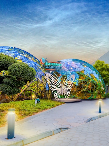 Butterfly Gardens entrance with geometric dome and illuminated butterfly sculpture.