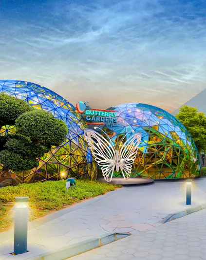 Butterfly Gardens entrance with geometric dome and illuminated butterfly sculpture.
