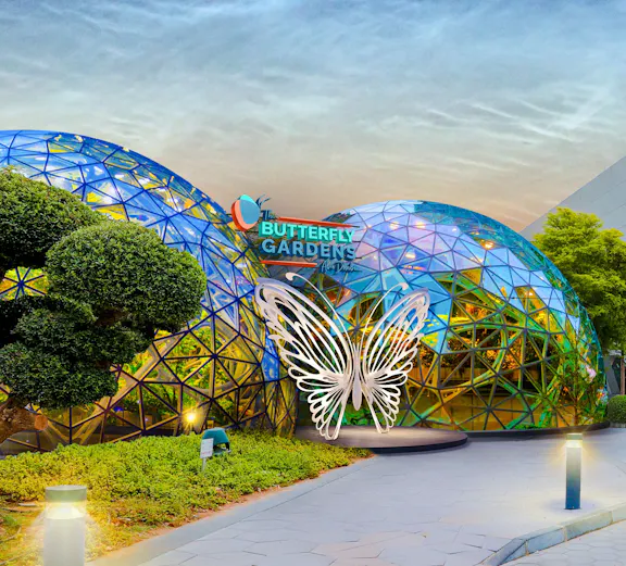 Butterfly Gardens entrance with geometric dome and illuminated butterfly sculpture.
