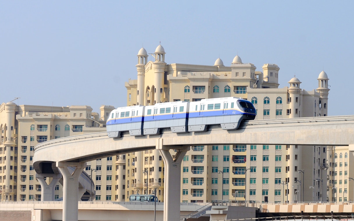 Dubai monorail passing in front of Palm Jumeirah buildings.