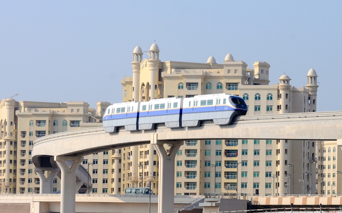 Dubai monorail passing in front of Palm Jumeirah buildings.