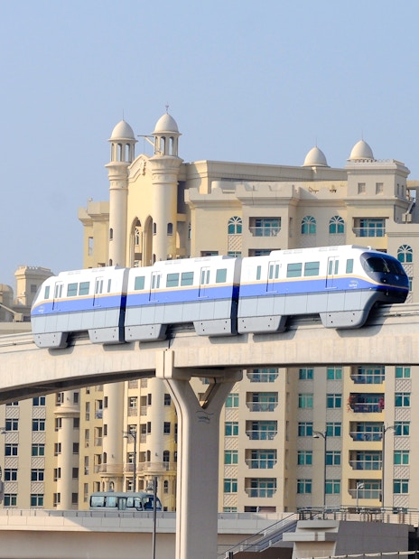 Dubai monorail passing in front of Palm Jumeirah buildings.