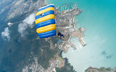 Tandem skydive over Airlie Beach with view of coastline and marina.