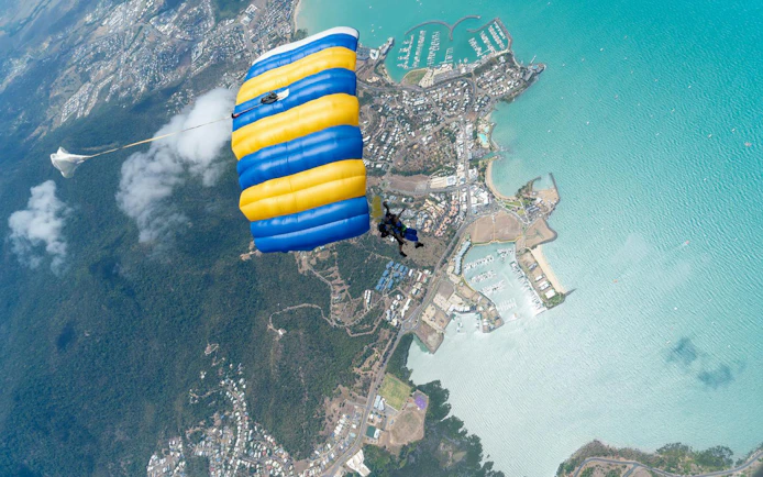 Tandem skydive over Airlie Beach with view of coastline and marina.