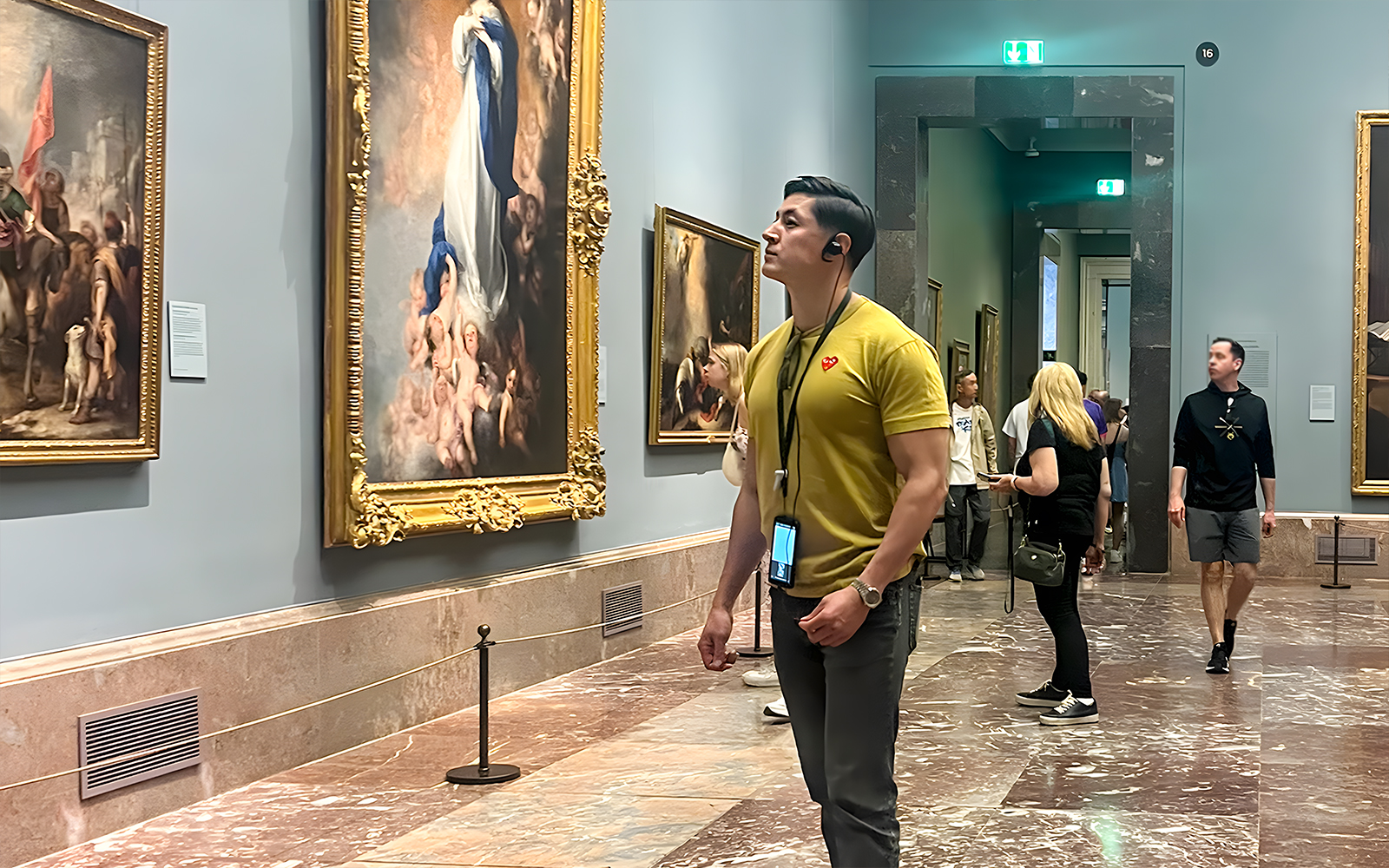 Visitors admiring paintings inside Prado Museum, Madrid.