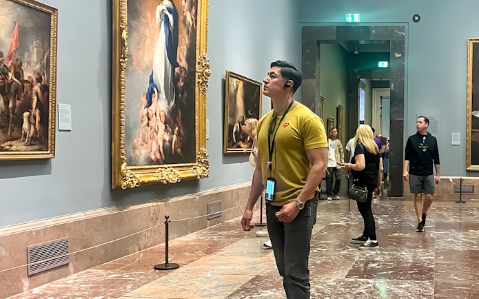 Visitors admiring paintings inside Prado Museum, Madrid.