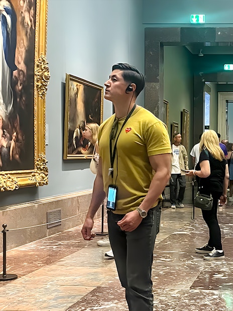 Visitors admiring paintings inside Prado Museum, Madrid.