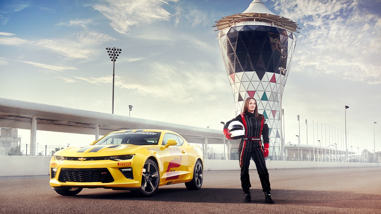 Chevrolet Camaro SS at Yas Marina Circuit with driver in racing suit holding helmet.
