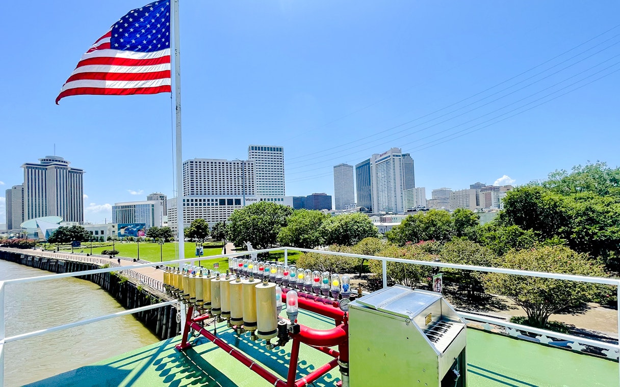 Deck view of CITY of NEW ORLEANS Riverboat with New Orleans skyline in the background.