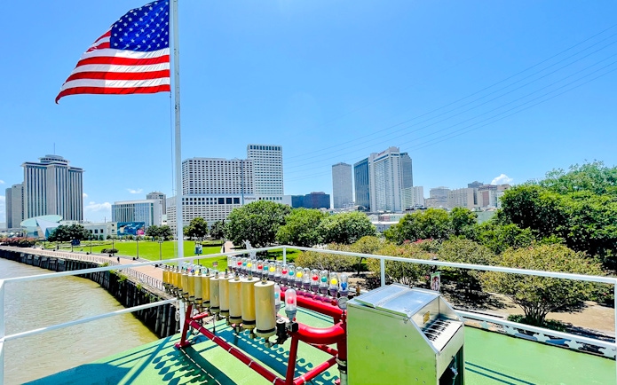 Deck view of CITY of NEW ORLEANS Riverboat with New Orleans skyline in the background.