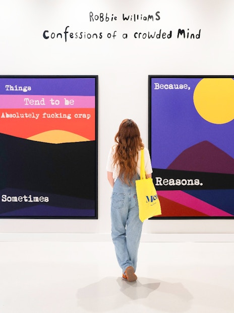 Woman viewing colorful art at Moco Museum exhibit.