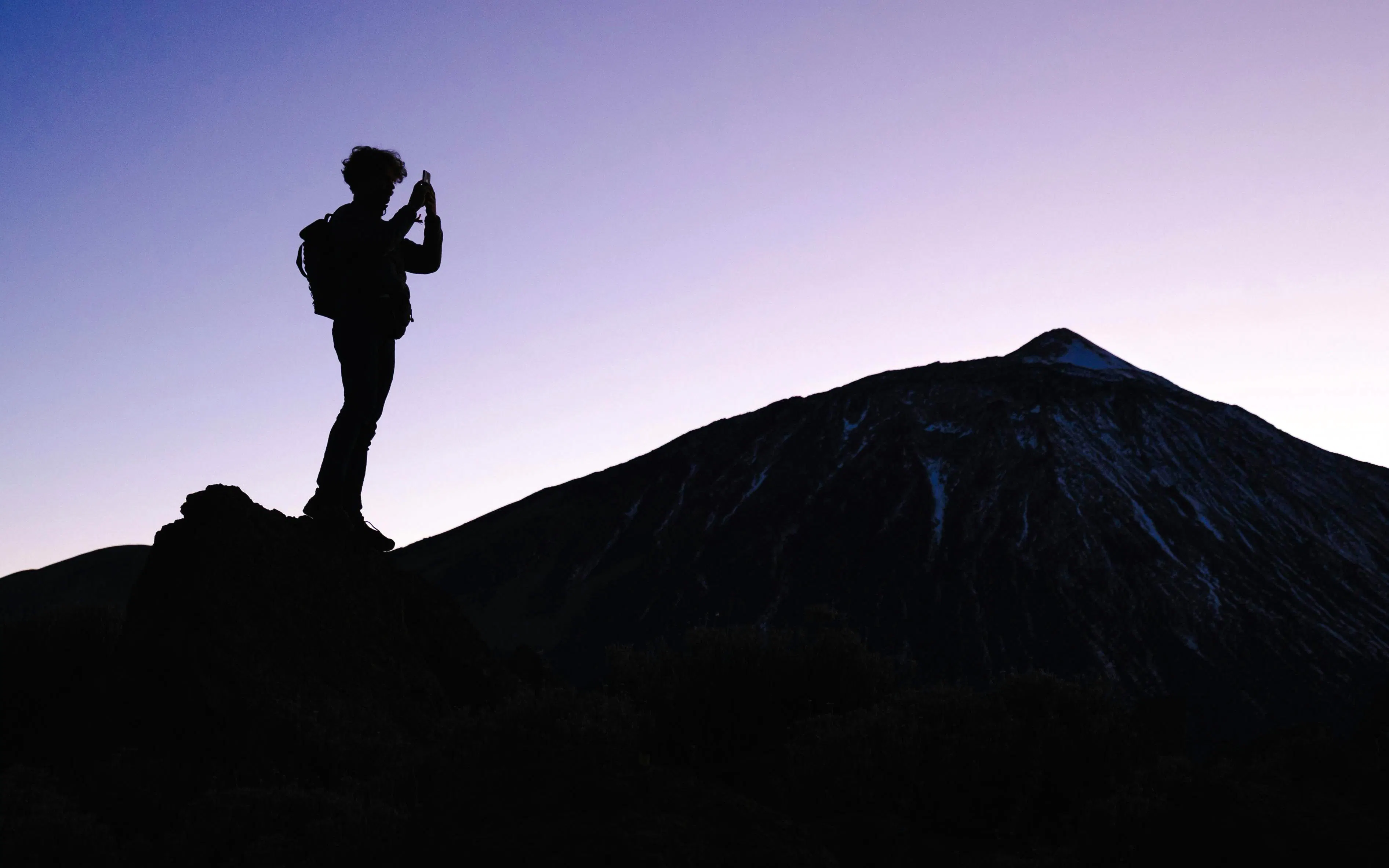 Tourist photographing Mount Teide at dusk, Tenerife.
