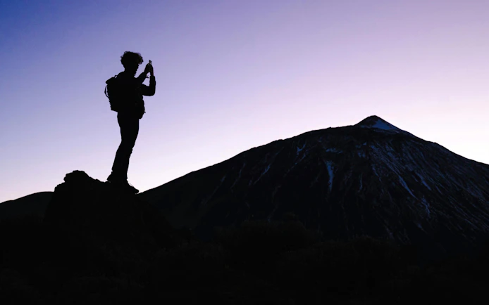 Tourist photographing Mount Teide at dusk, Tenerife.