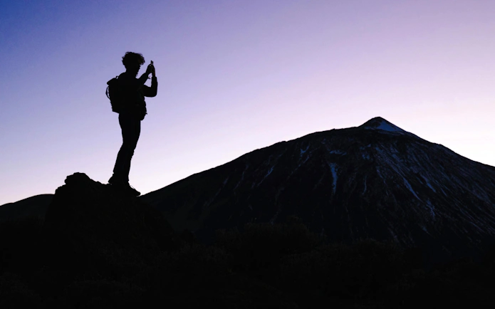 Tourist photographing Mount Teide at dusk, Tenerife.