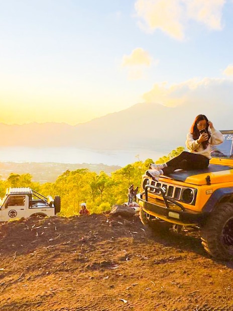 Tourist on jeep during Mount Batur sunrise tour with scenic view in Bali.
