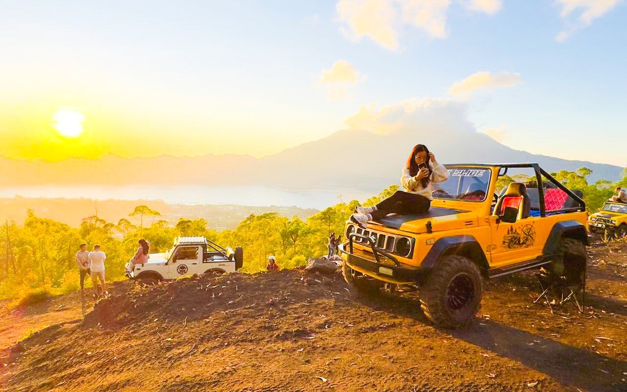 Tourist on jeep during Mount Batur sunrise tour with scenic view in Bali.