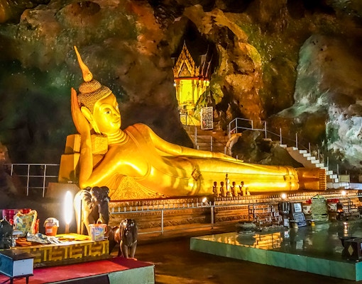 Reclining Buddha statue inside Wat Suwan Kuha temple cave, Thailand.