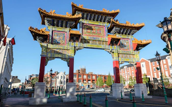 Chinese Arch in Liverpool's Chinatown with surrounding buildings.