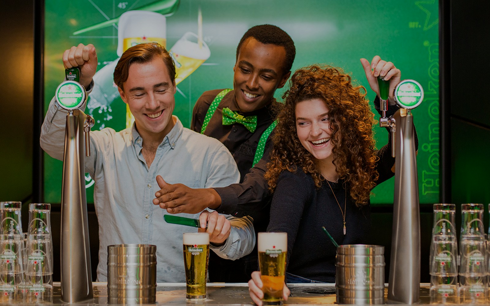 Visitors pouring beer at Heineken Experience in Amsterdam.