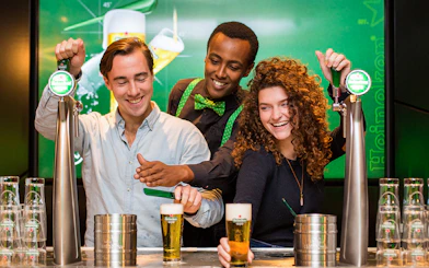 Visitors pouring beer at Heineken Experience in Amsterdam.