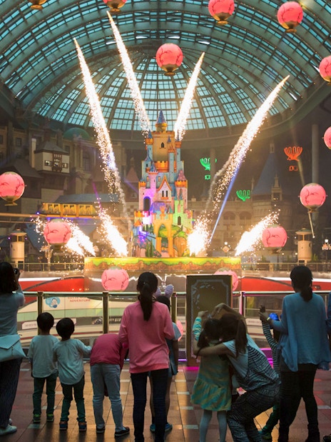 Fireworks display at Lotte World with a crowd watching inside the theme park.