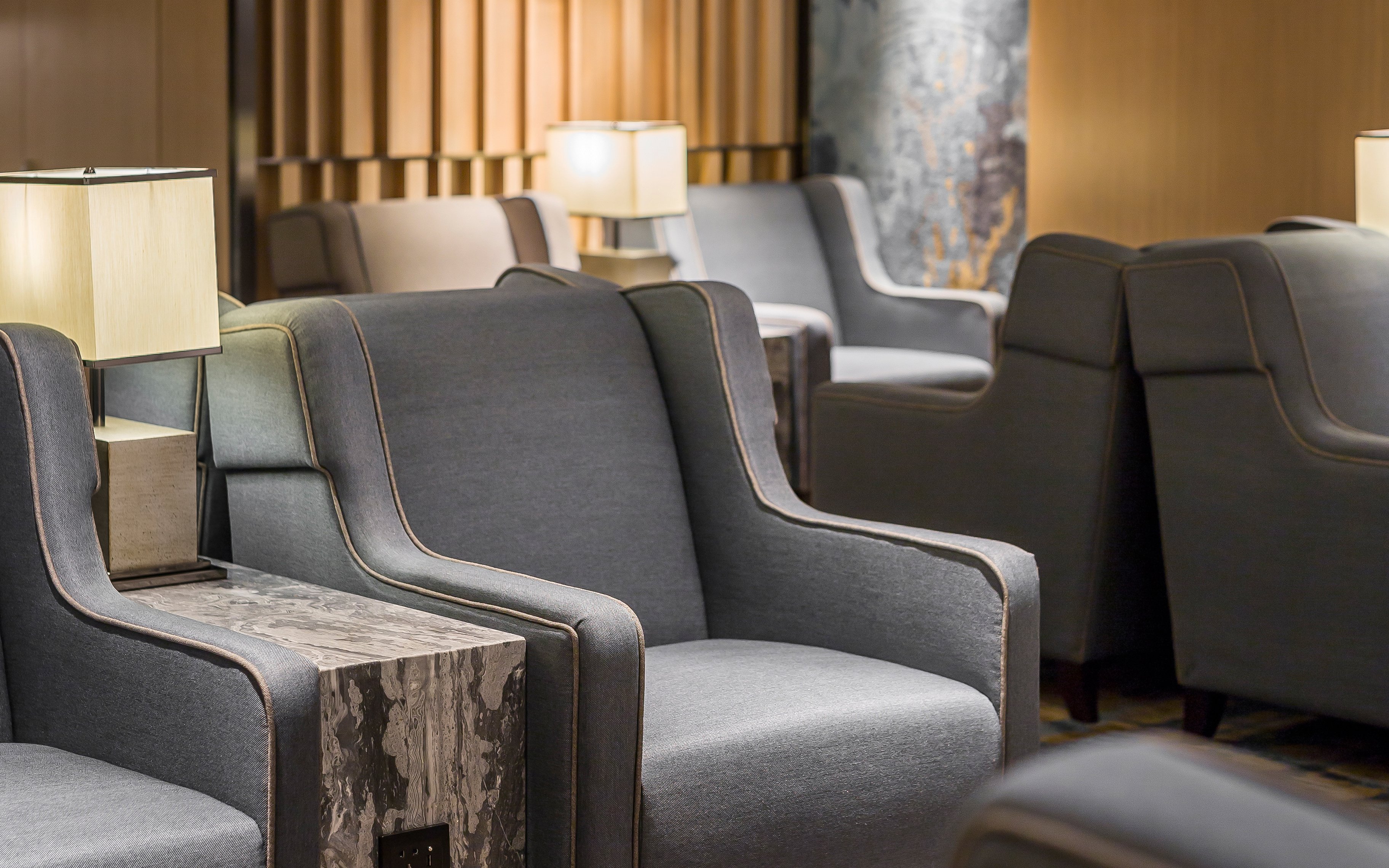 Seating area in Plaza Premium Lounge, Zone D, Taipei, Taiwan with armchairs and lamps.