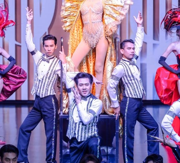 Calypso Cabaret performers in elaborate costumes on stage, Bangkok.
