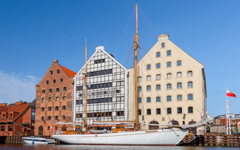 Gdansk Maritime Museum with sailboat on Motlawa River.
