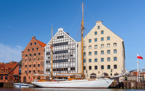 Gdansk Maritime Museum with sailboat on Motlawa River.