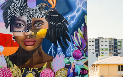 Colorful street art mural featuring a woman's face and bird, part of a 3.5-hour art tour.