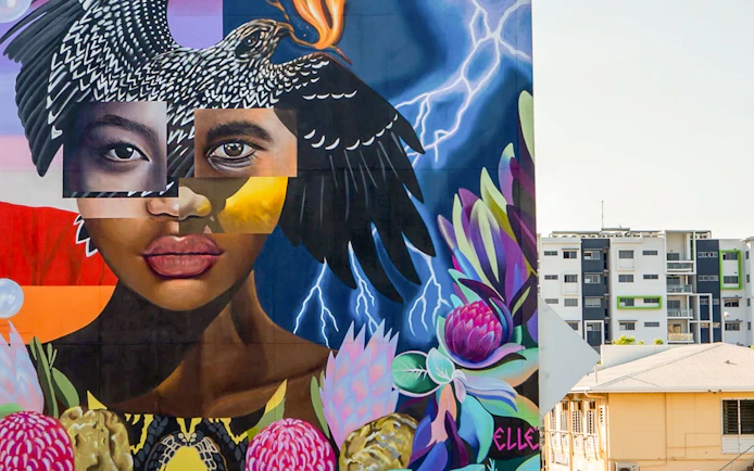 Colorful street art mural featuring a woman's face and bird, part of a 3.5-hour art tour.